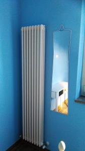 un radiateur sur une paroi bleue à côté d'un miroir dans l'établissement Domus Bolsena, à Bolsena