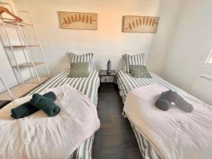 two beds with teddy bears on them in a room at Duplex à proximité de la place Stanislas in Heillecourt