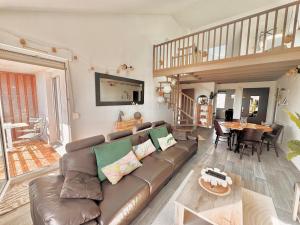 a living room with a brown couch and a table at Duplex à proximité de la place Stanislas in Heillecourt