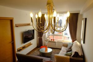 a living room with a couch and a chandelier at Apt in the Sky - Kopaonik Kraljevi Čardaci in Kopaonik