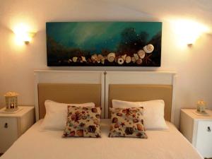 um quarto com uma cama com um quadro na parede em Skiathos Driades em Koukounaries