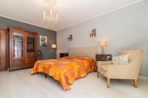 a bedroom with a bed and a chair and a chandelier at Ca du Aldo - La Crema in Finale Ligure