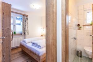 a bedroom with a bed and a bathroom with a shower at Neuhof Appartements in Maishofen +86 photos