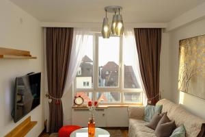 a living room with a couch and a large window at Apt in the Sky - Kopaonik Kraljevi Čardaci in Kopaonik
