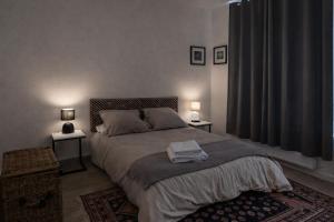 a bedroom with a bed with two lamps on two tables at Creil Sud, près de l'Oise in Creil