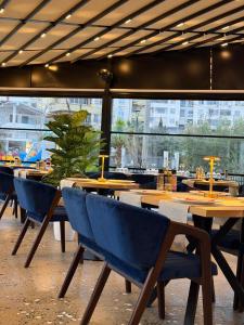 a restaurant with wooden tables and blue chairs at Vila Lira in Durrës