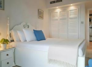 a bedroom with two white beds with blue pillows at Unique cozy villa sea view in Hurghada