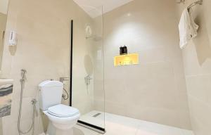 a white bathroom with a toilet and a shower at سديم الفخر 2 للشقق الفندقية in Taif