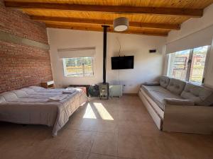 a bedroom with a bed and a couch and a tv at Laguna de los Cisnes in Perito Moreno +28 photos