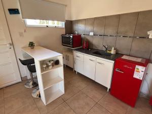 a small kitchen with a red refrigerator and a microwave at Laguna de los Cisnes in Perito Moreno