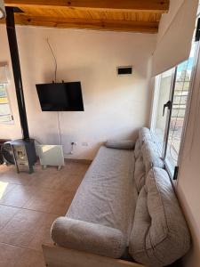 a living room with a couch and a flat screen tv at Laguna de los Cisnes in Perito Moreno
