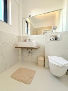 a white bathroom with a sink and a toilet at Amira Residence in Eforie Nord +99 photos