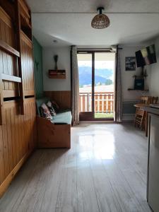 a living room with a large window and a table at Studio en station de ski familiale, vue sur les montagnes in La Morte