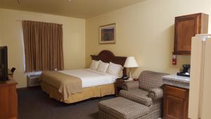 una stanza d'albergo con un letto e una sedia di Reddy Hotel a Plainview