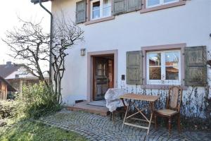 a table and two chairs in front of a house at Zurück zur Wurzel in Karsau