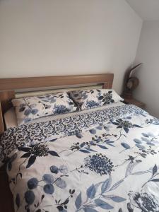 a bed with a blue and white comforter and pillows at Casa Bella Loznica in Loznica