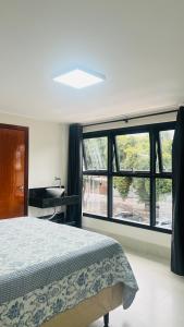 a bedroom with a bed and a large window at Hotel MM AEROPORTO BRASÍLIA in Núcleo Bandeirante