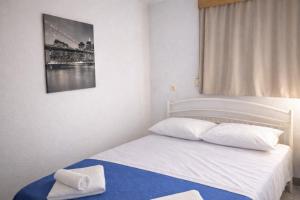 a bedroom with a bed with a towel on it at Ntolos House Old Town in Kavála