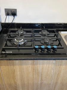 a stove top with blue knobs on a kitchen counter at ShowLove Luxury Apartment in Lekki Phase 1