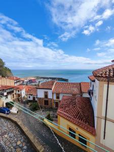 a view of a town with the ocean in the background at Cau La Mar in Lastres