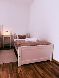 a white bed in a room with a wooden floor at Apartments Pablo Novalja in Novalja