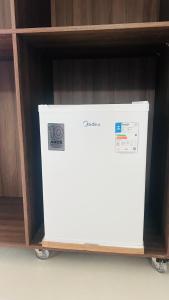 a white refrigerator sitting in a shelf at Hotel MM AEROPORTO BRASÍLIA in Núcleo Bandeirante