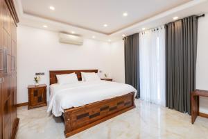 a bedroom with a large bed with white sheets at Lasantha's Residence in Kadawata
