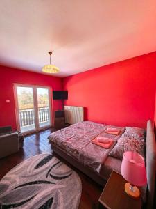 a bedroom with a large bed and a red wall at Apartmani Vita in Divčibare