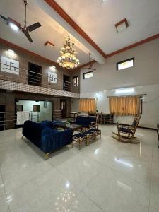 a large living room with a blue couch and chairs at Vedanta Retreat in Igatpuri