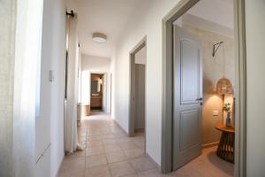 a hallway with white walls and a door and a table at Villa Pothaia in Myrties +18 photos