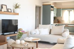 a living room with a white couch and a tv at Villa Pothaia in Myrties