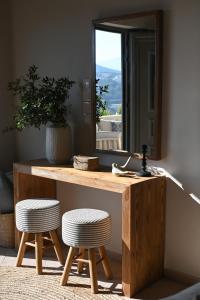 a wooden table with two stools in front of a mirror at Villa Pothaia in Myrties