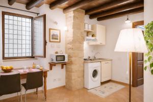 a kitchen with a table and a washing machine at Damiani Case Vacanze Palermo - Centro Storico in Palermo