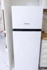 a white refrigerator freezer sitting in a kitchen at Ntolos House Old Town in Kavála +7 photos