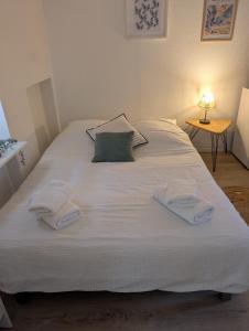 a large white bed with two towels on it at L'oiseau Bleu - Clim - Tout inclus - Terrasse in Aubagne