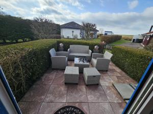 a patio with couches and tables and a fire pit at Ferienhaus Meeresbrise in Wurster Nordseeküste