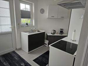 a small kitchen with a sink and a stove at Ferienhaus Meeresbrise in Wurster Nordseeküste +9 photos