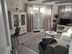 a living room with a couch and a table at Ferienhaus Meeresbrise in Wurster Nordseeküste