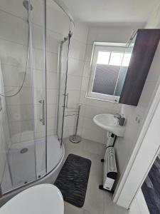 a bathroom with a shower and a toilet and a sink at Ferienhaus Meeresbrise in Wurster Nordseeküste