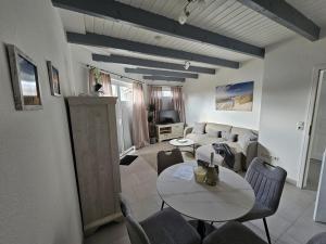 a living room with a table and a couch at Ferienhaus Meeresbrise in Wurster Nordseeküste