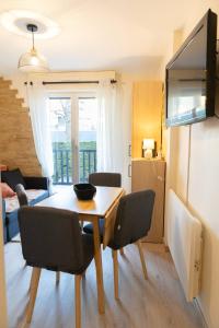 a living room with a dining room table with chairs at Le reflet de Cabourg avec accès direct plage in Cabourg