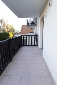 a walkway in a house with a black fence at Le reflet de Cabourg avec accès direct plage in Cabourg