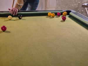 a man playing pool with balls on a pool table at Hôtel des arts - Gîte Littérature dans le Perche - Spa in Rémalard +22 photos