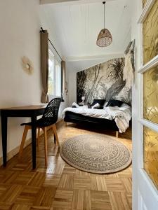 a bedroom with a bed and a desk and a table at Cabercé Thoiré in Thoiré-sur-Dinan