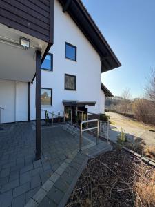 a white building with a fireplace in front of it at Ferienwohnung Voges in Bad Lauterberg