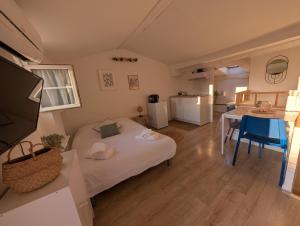 a room with a bed and a table and a kitchen at L'oiseau Bleu - Clim - Tout inclus - Terrasse in Aubagne
