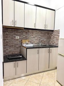a kitchen with white cabinets and a sink at Villa Mare Blue in Ksamil +48 photos