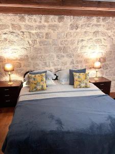 a bedroom with a blue bed with two lamps at 22 THE STRADUN in Dubrovnik