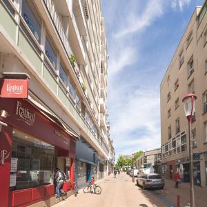 a person riding a bike down a city street at Le Repaire - Hyper centre, 3 ch, balcon et parking in Le Mans