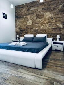 a large white bed in a room with a brick wall at SF Apartments Lux in Dobra Voda +118 photos